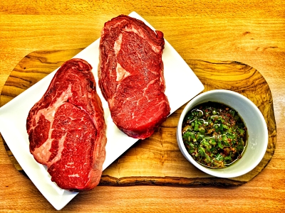Raw steaks with chimichurri